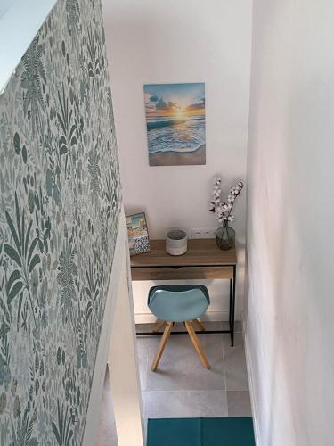 un bureau avec une chaise bleue à côté d'une table dans l'établissement Appartement classé 3 étoiles face à la plage de la Nartelle, à Sainte-Maxime