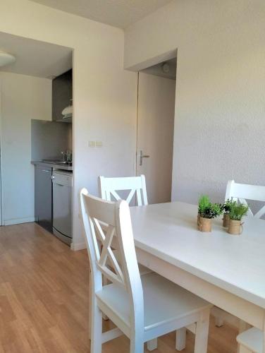- une cuisine avec une table et des chaises blanches dans l'établissement Appartement 2 pièces Ile D'Or, à La Londe-les-Maures