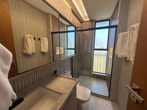 ein Badezimmer mit Waschbecken und großem Spiegel in der Unterkunft Amura Carneiros apartamento 3 quartos com piscina privativa in Praia dos Carneiros