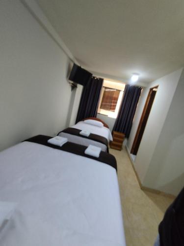 a group of four beds in a room at Kuntur House Machupicchu in Machu Picchu