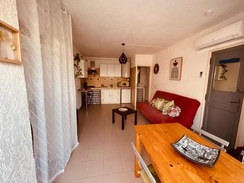 un salon avec un canapé rouge et une table dans l'établissement GStudio climatisé avec terrasse 300 m de la plage expo sud cosy que du bonheur, au Grau-du-Roi