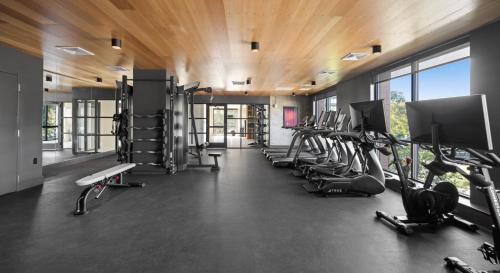 a gym with a row of treadmills and machines at Luxury Apartments by Hyatus Boston Somerville in Somerville