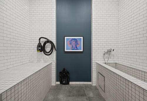 a bathroom with two sinks and a painting on the wall at Luxury Apartments by Hyatus Boston Somerville in Somerville