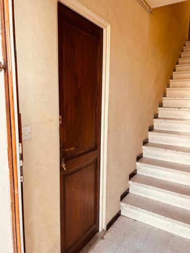 une porte ouverte d'un immeuble avec des escaliers dans l'établissement GStudio climatisé avec terrasse 300 m de la plage expo sud cosy que du bonheur, au Grau-du-Roi