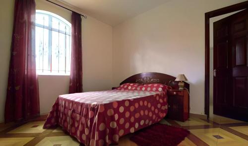 a bedroom with a bed with a table and a window at Rama Villas Mauritius in Trou aux Biches
