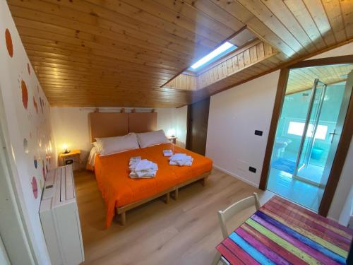 a bedroom with an orange bed with towels on it at Marameo B&B in Udine