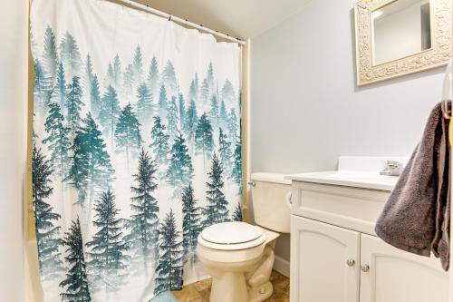 a bathroom with a shower curtain of a pine forest at 4 Mi to Lake Superior Calumet Getaway! in Calumet