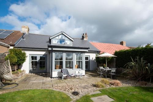 a white house with a patio with a table and chairs at Number Nine in Lanchester