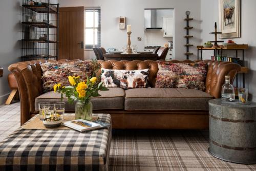 a living room with a brown couch and a table at Number Nine in Lanchester