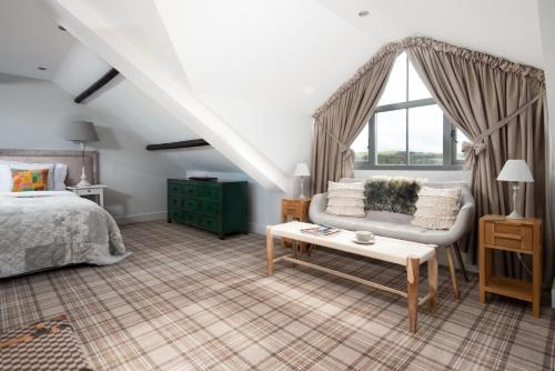 a bedroom with a bed and a couch and a window at Number Nine in Lanchester