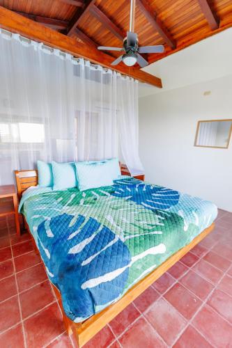 a bed in a room with a ceiling fan at Hotel Planeta Sano in Manuel Antonio