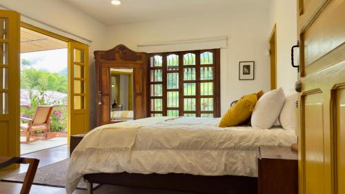a bedroom with a bed and a door to a patio at Hotel Mandalay 1941 in Pereira