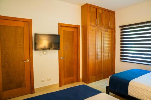 a bedroom with a bed and a tv on the wall at Xeliter Balcones del Atlantico - Las Terrenas in Las Terrenas