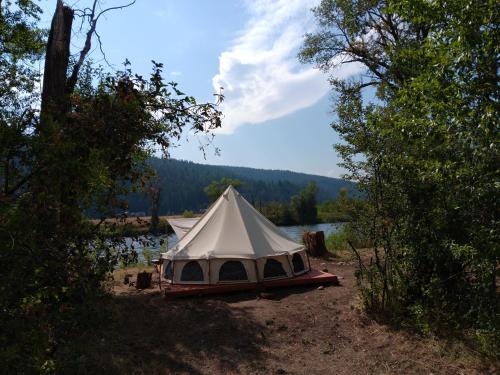 a white tent sitting on the side of a lake at Snake River Glamping in Irwin