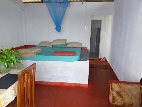 a bedroom with a bed and a table and chairs at Inuli Coco Hut in Kalutara