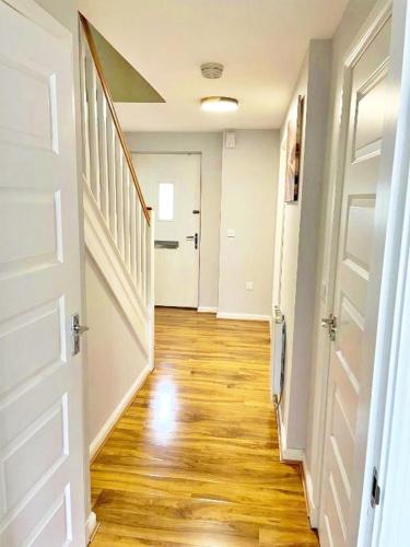 an empty hallway of a home with a wooden floor at 3 bed house with parking near airport in Edinburgh