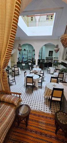a restaurant with tables and chairs and a couch at Ryad 91 in Casablanca