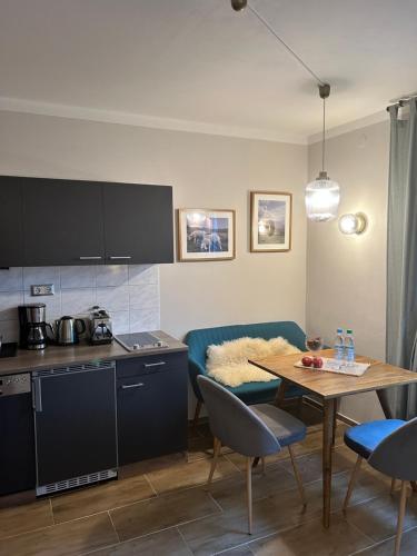 a kitchen and living room with a table and a couch at Großes Apartment mit Terrasse und Garten in Oberhaching