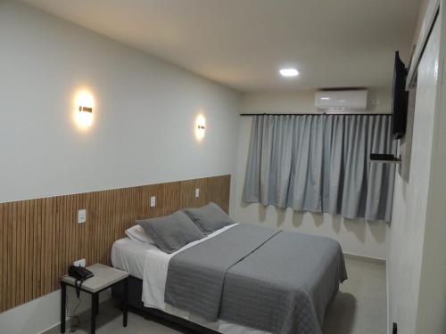 ein Schlafzimmer mit einem Bett und einem Fenster in der Unterkunft NC Hotel in Bragança Paulista