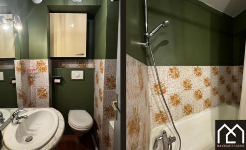une salle de bain verte avec un lavabo et une douche dans l'établissement Chez Perrine, Magnifique Appartement Face aux Remparts, à Boulogne-sur-Mer