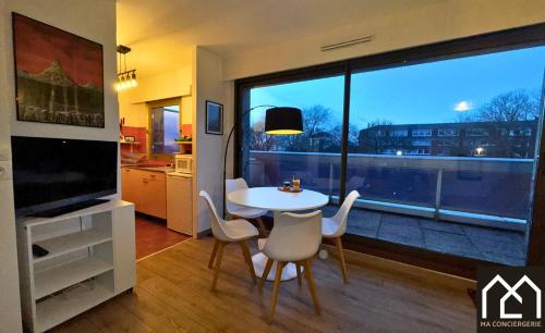 - un salon avec une table, des chaises et une grande fenêtre dans l'établissement Chez Perrine, Magnifique Appartement Face aux Remparts, à Boulogne-sur-Mer