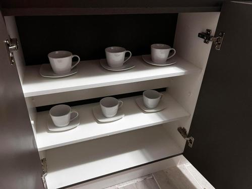 a cupboard with four cups and saucers on them at Departamento a pasos de la playa in Arica