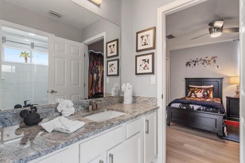 Un baño con lavabo y una cama en una habitación. en Skyblue Villas, en Haines City