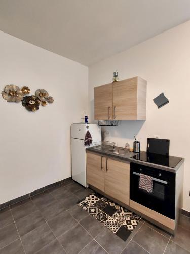 a kitchen with a stove and a refrigerator at Crezilles Hôtes in Crézilles