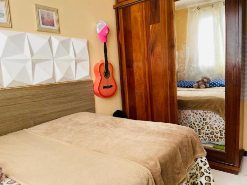 a bedroom with a guitar on the wall and two beds at Apartamento em condomínio para a COP30 in Marituba