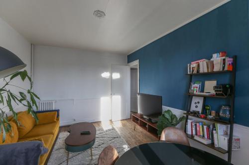 - un salon avec des murs bleus, une table et des chaises dans l'établissement Nice T2 of 40 m close to Paris Parc André Citroën, à Paris