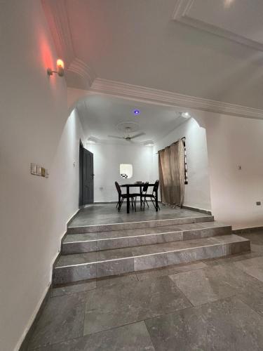 a dining room with a table and some stairs at Best Point Home in Kokrobite