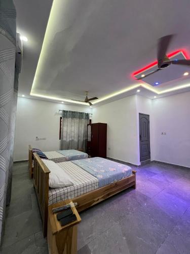 a room with two beds and a red light at Best Point Home in Kokrobite