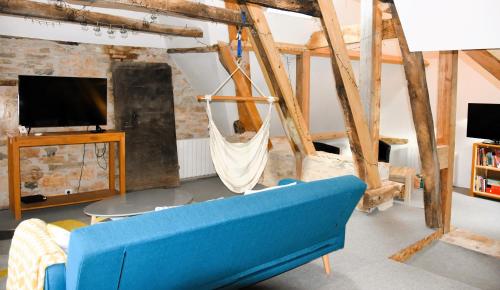 a living room with a blue couch and a tv at Sous les étoiles du Causse in Espédaillac