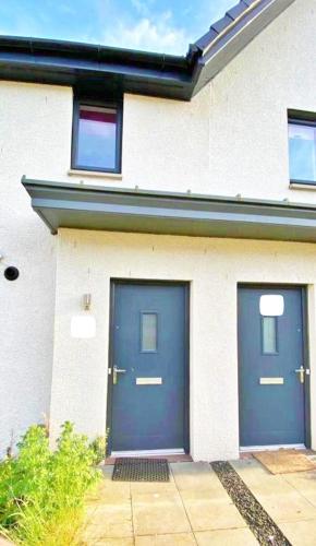 a building with two blue doors on it at 3 bed house with parking near airport in Edinburgh