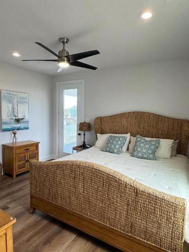 a bedroom with a large bed with a ceiling fan at Hideaway in Freeport