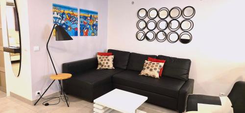 un salon avec un canapé noir et une table dans l'établissement Didalie locations lavande, à Sainte-Maxime