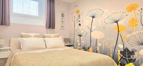 - une chambre avec un lit orné de fleurs sur le mur dans l'établissement Didalie locations lavande, à Sainte-Maxime