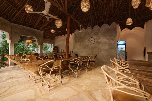 a dining room with a long table and chairs at African Bungalows in Nungwi