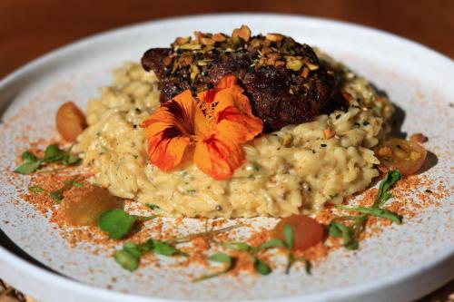 a white plate of food with a flower on it at Hotel El Cielo en la Tierra in Quimbaya