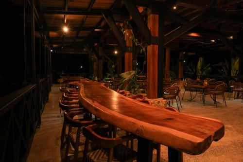 a long wooden table and chairs in a restaurant at Hotel El Cielo en la Tierra in Quimbaya
