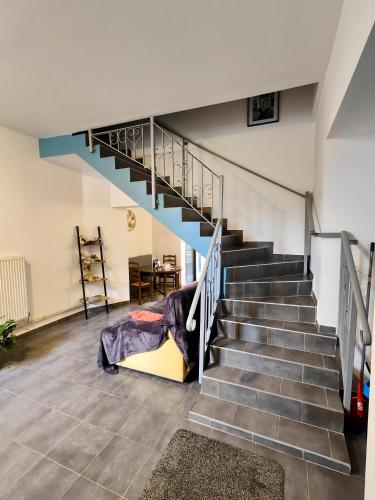 a room with stairs with a bed and a table at Crezilles Hôtes in Crézilles
