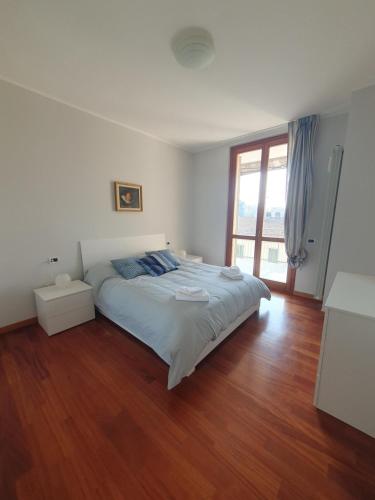 a bedroom with a large bed and a wooden floor at Il Belvedere 10 in Cassano dʼAdda