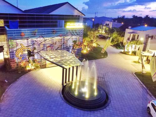 a park bench with a fountain in front of a building at MaxOneHotels at Resort Makassar in Makassar