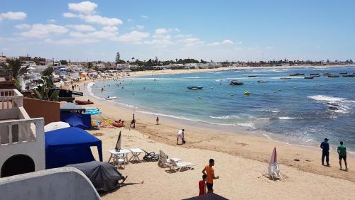 a beach with people on the sand and the water at Beautiful Apartment with Seaside Pool in Mansouria