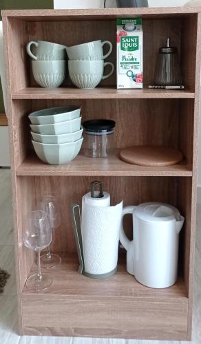 une étagère avec des bols, des assiettes et un verre de vin dans l'établissement Studio 