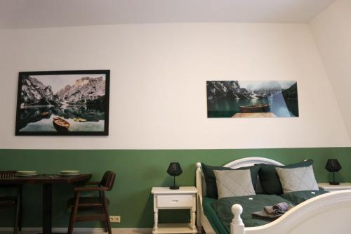 a bedroom with a green and white bed and a table at SchaeBu! 6 Apartment Altmarkt im Grünen in Cottbus