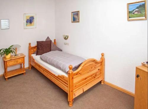 a bedroom with a wooden bed and a night stand at Auerhahn Bed and Breakfast - Black Forest - Waldhotel in Eisenbach