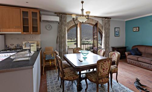 a kitchen and living room with a table and chairs at Casa Rural Gite El Tossal in Collfred