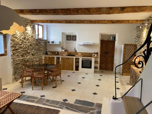 une cuisine avec une table et des chaises dans une pièce dans l'établissement Charmante Maison de Village, à Banyuls-sur-Mer