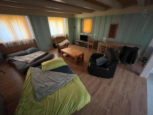 a living room with a bed and a couch and a table at Historische Maisonettewohnung bis 10 Gäste, Magic Pass Belalp, Rosswald und mehr in Naters